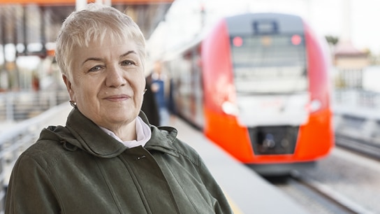 Frau am Bahnsteig während Zug einfährt