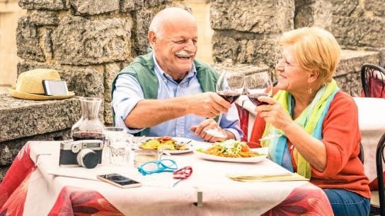 Mann und Frau stoßen mit einem Glas Rotwein an