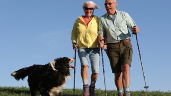 älteres Pärchen beim Wandern mit Hund