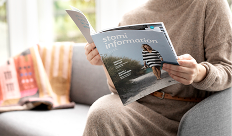 Person sitzt und liest in einem Stoma-Magazin